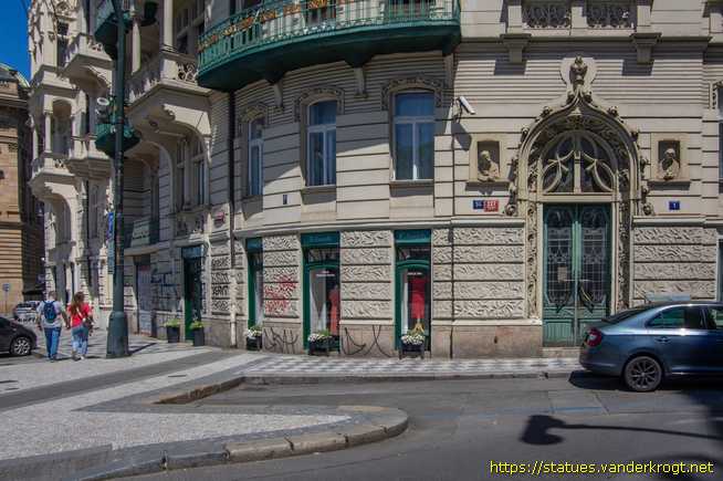 Praha /  Dvě polofigurky, které vykukují z 'oken'