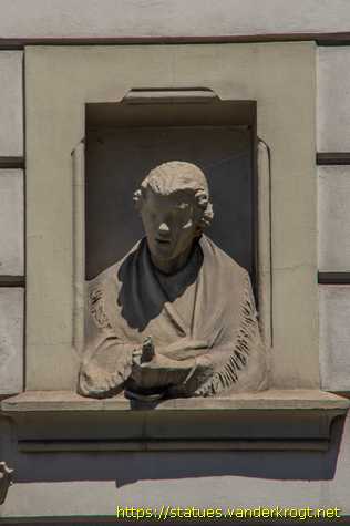 Praha - Dvě polofigurky, které vykukují z 'oken'
