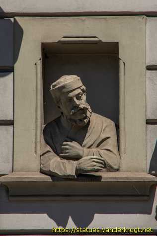 Praha - Dvě polofigurky, které vykukují z 'oken'